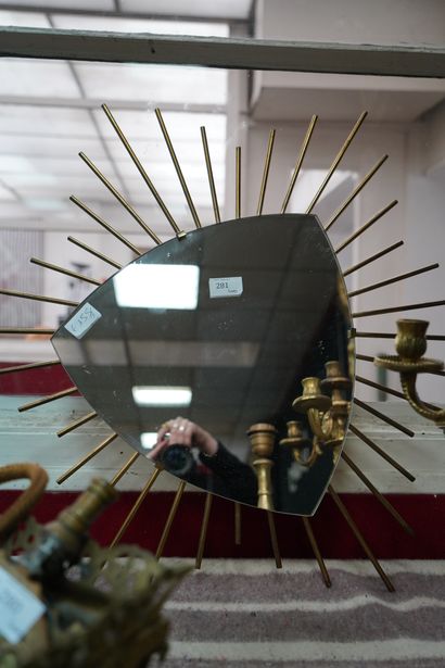 Miroir de forme écusson sur un fond rayonnant...