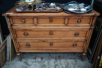 Une commode en bois teinté ouvrant à trois...