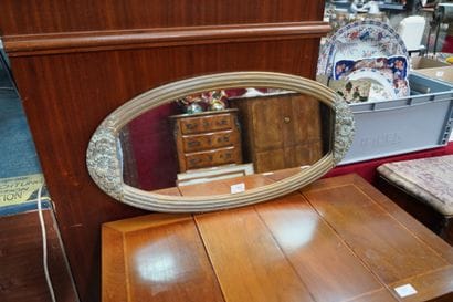 Miroir ovale en bois doré et patiné, mouluré...