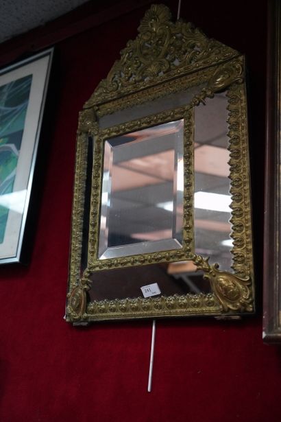 Miroir à profil inversé en métal doré à décor...