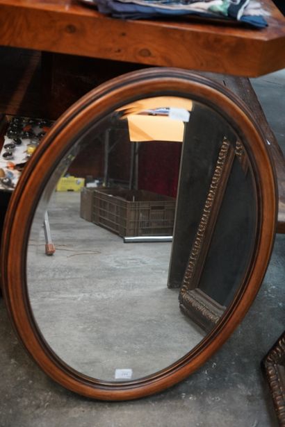 Miroir ovale, l'encadrement en bois mouluré.
En...