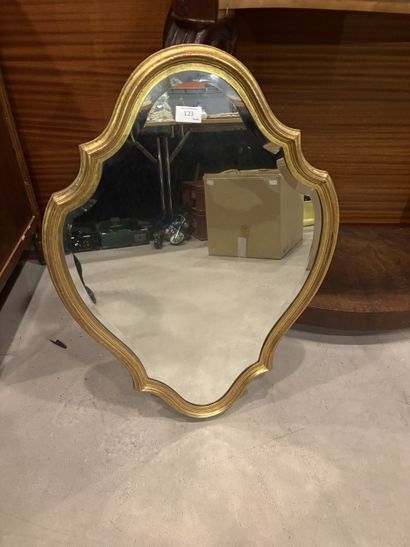 Miroir en composition dorée, de forme chantournée.
En...