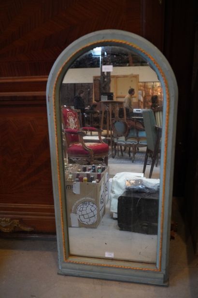 Miroir en bois peint, de forme cintré.
En...
