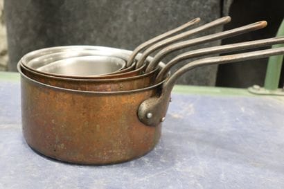 Batterie de cinq casseroles en cuivre.
