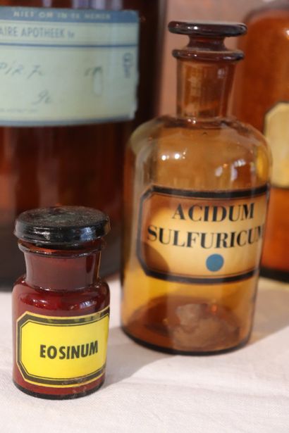 Suite de huit pots à pharmacie en verre ambre....