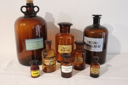 Suite de huit pots à pharmacie en verre ambre....
