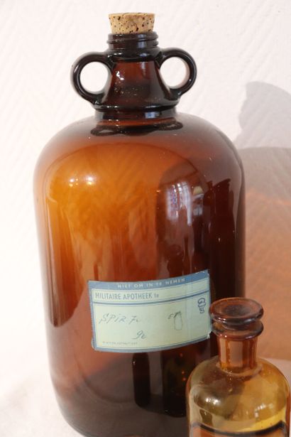 Suite de huit pots à pharmacie en verre ambre....