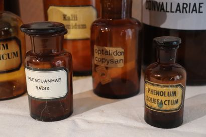Suite de huit pots à pharmacie en verre ambre....