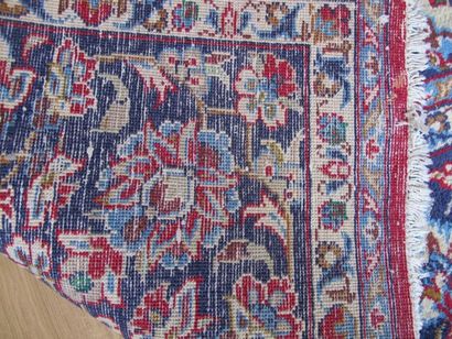 Tapis persan en laine à fonds bleu à bordure...
