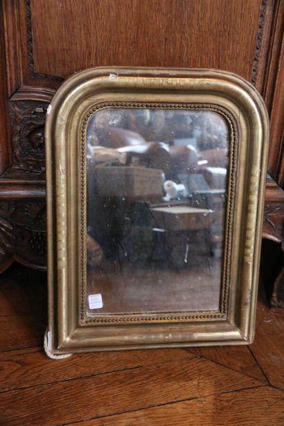 Miroir ovale en bois sculpté et doré, surmonté...