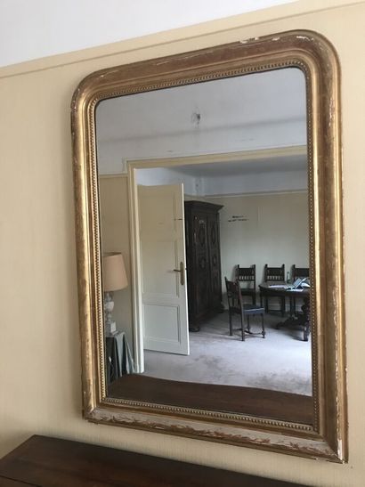 Grand miroir en bois doré à décor sculpté...