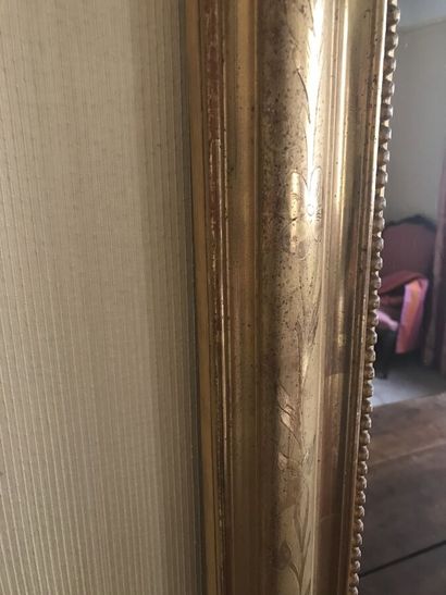 Grand miroir en bois doré à décor sculpté...