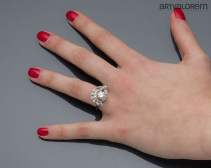Platinum ring centered on a brilliant-cut...