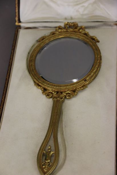 Gilt bronze hand mirror, the circular bevelled...