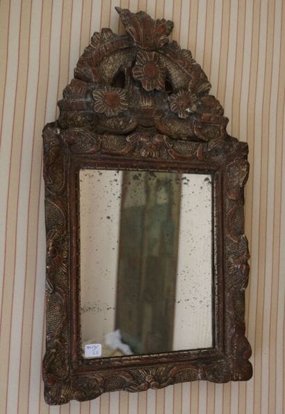 Mirror in patinated and carved wood, the...