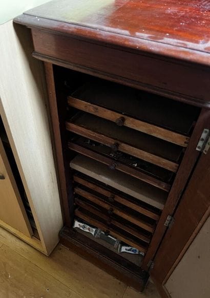 Walnut silverware cabinet opening by a door
H....