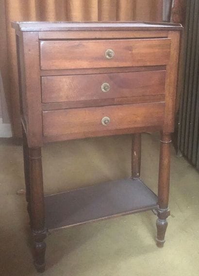 Natural wood bedside table opening with three...