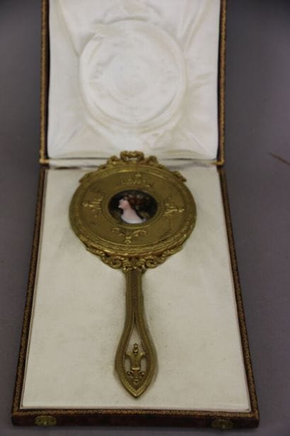 Gilt bronze hand mirror, the circular bevelled...