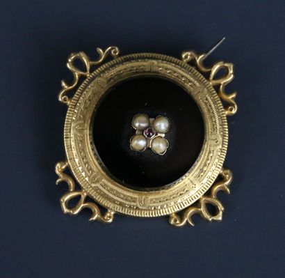 Circular brooch in chased and engraved yellow...