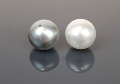 Two cultured pearls, one white and one gray...