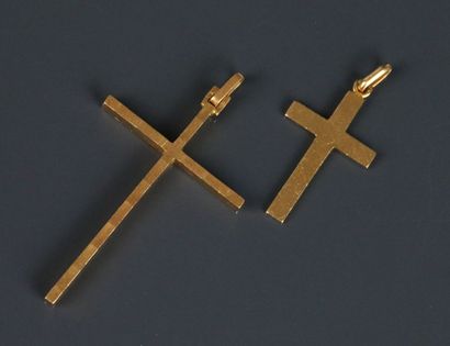 Two cross-shaped pendants in yellow gold...