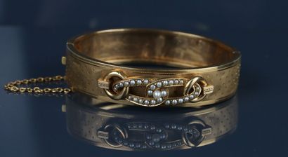 Gold bangle on a guilloché and pastillé ground...