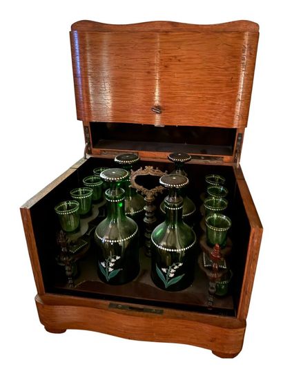 Une cave à liqueur en chêne clair contenant...