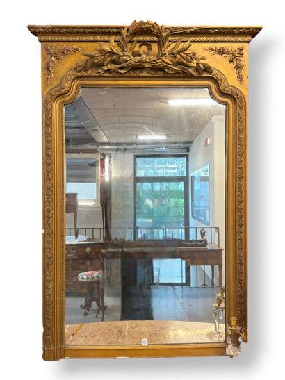 Grand miroir en bois et stuc doré surmonté...
