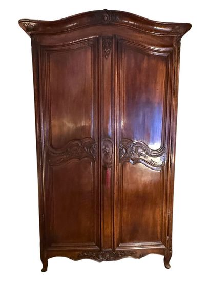 A molded and carved mahogany cabinet decorated...