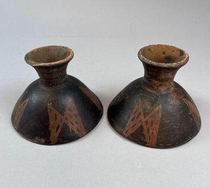 Two terracotta cups on a pedestal with geometric...
