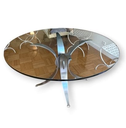 Round glass table with a chrome-plated metal...