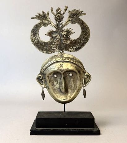 Stylized mask made of chiseled metal, topped...