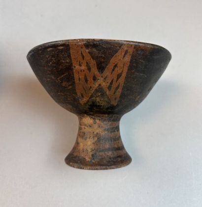 Two terracotta cups on a pedestal with geometric...