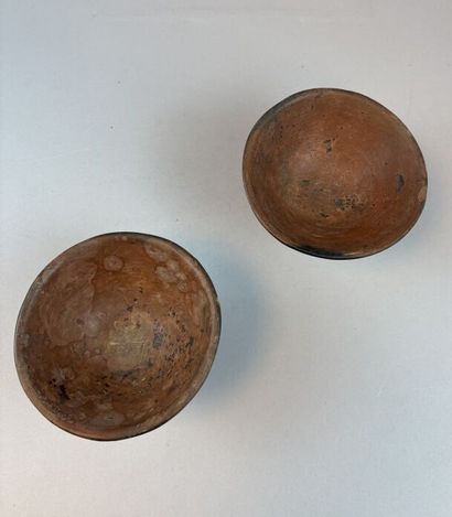 Two terracotta cups on a pedestal with geometric...