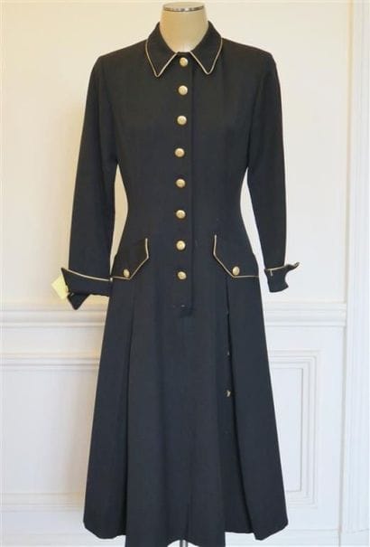 Una
Robe manteau noir avec boutons dorés...