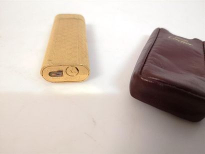 CARTIER. Briquet en plaqué or guilloché....