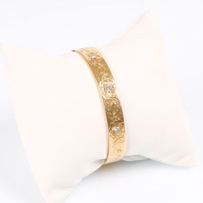 Bracelet rigide ouvrant en or gravé de fleurs...