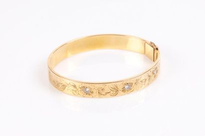Bracelet rigide ouvrant en or gravé de fleurs...