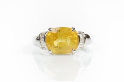 Bague en or gris sertie d'un saphir jaune...