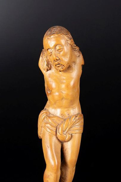 Petit Christ en buis sculpté, les yeux mi-clos,...