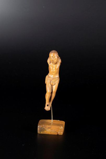 Petit Christ en buis sculpté, les yeux mi-clos,...