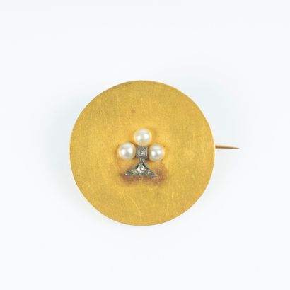 Broche en or, un disque uni piqué d'un motif...