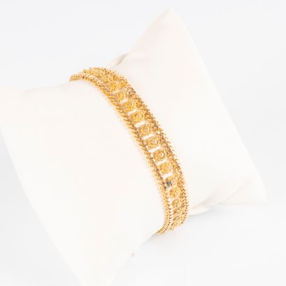 Bracelet souple en or ajouré de motifs filigranés....