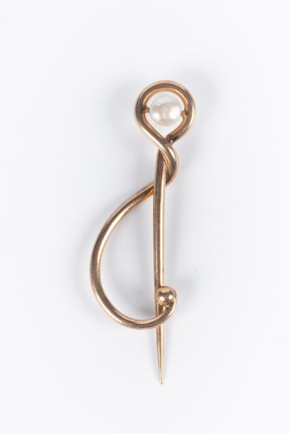 Epingle en or sertie d'une perle bouton....