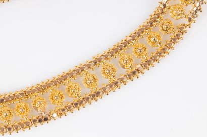 Bracelet souple en or ajouré de motifs filigranés....