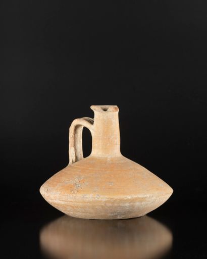 Cruche à panse carénée et anse quadrifide.
Terre...