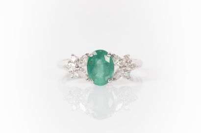 White gold ring set with an oval emerald...