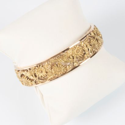 Bracelet rigide en or jaune à décor de fleurs....