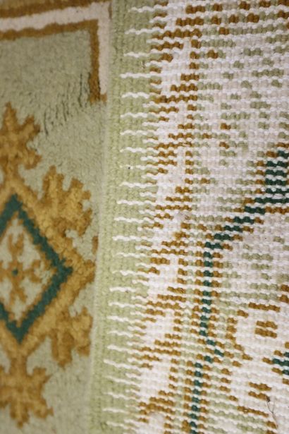 Wool carpet with beige background and stylized...