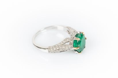 Two-tone gold ring set with an oval emerald...